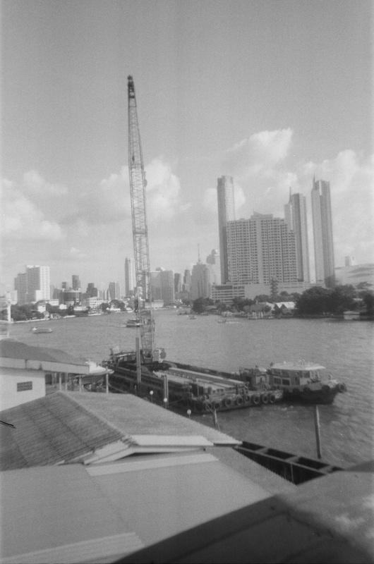 a crane on a barge docked on a riverside